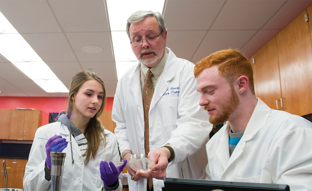 Prof. Michael Hanophy, Ph.D. in lab with two students