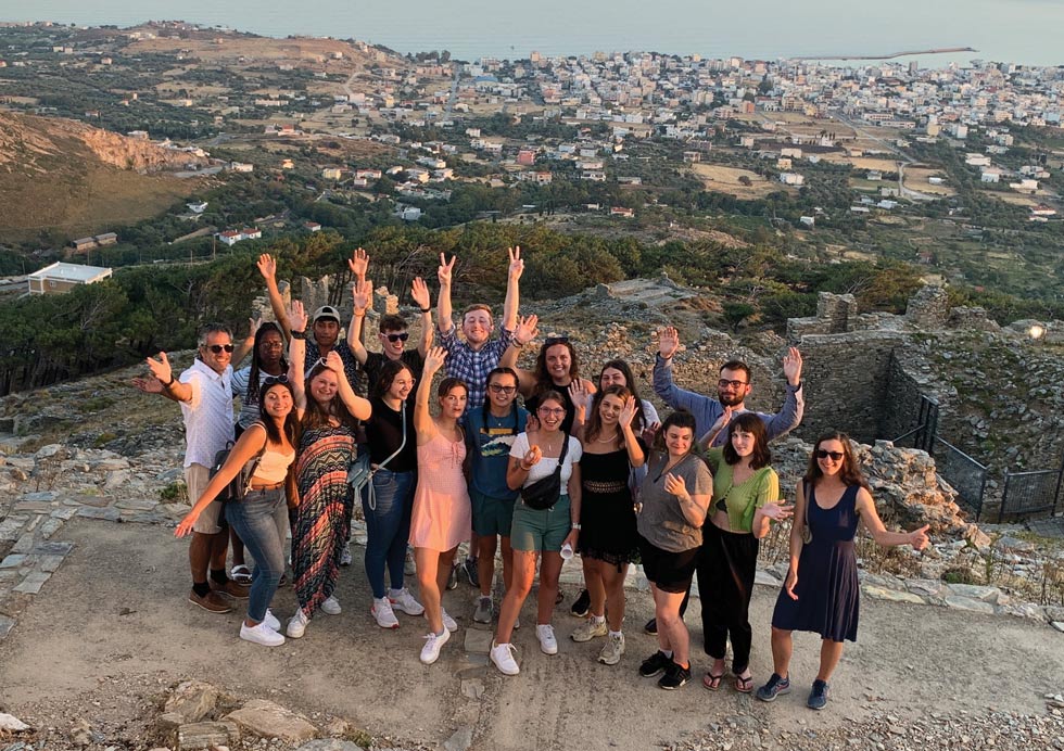 group of students and faculty posing for a posing for a picture together in Greece