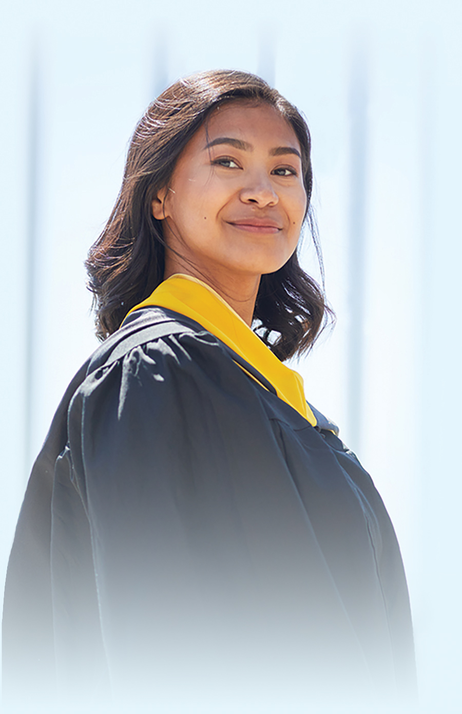 female student with cap and gown smiling