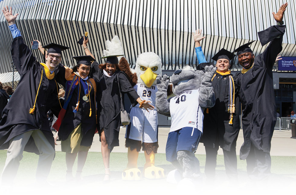 students in their caps and gowns, celebrating with the Long Island campus Eagle mascot and the Brooklyn campus Bear mascot