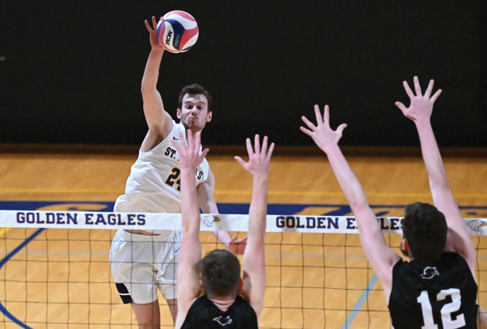 St. Joseph's mens volleyball player spiking the ball over the net