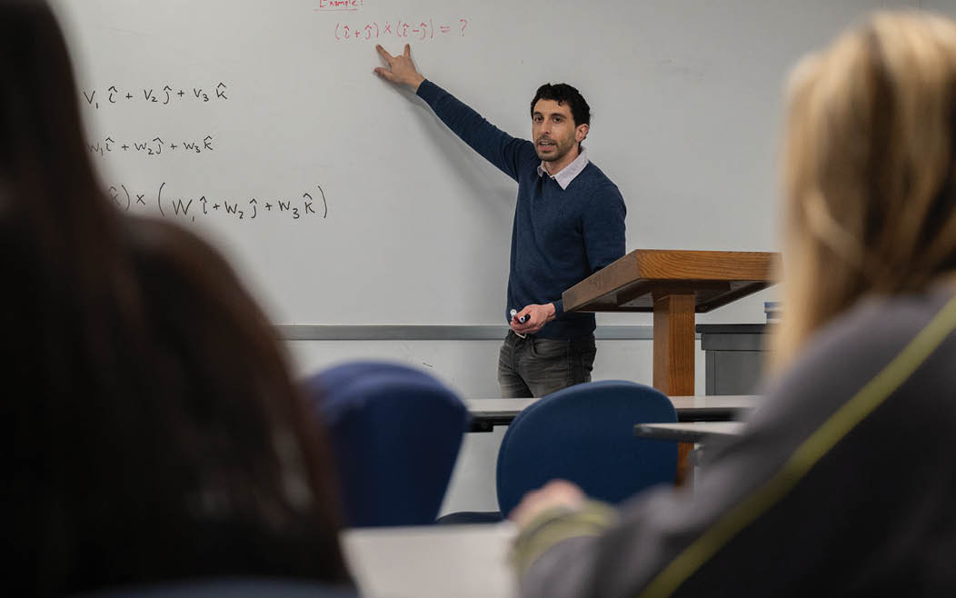 Thomas Mainiero, Ph.D., pointing to a math problem on the board during class