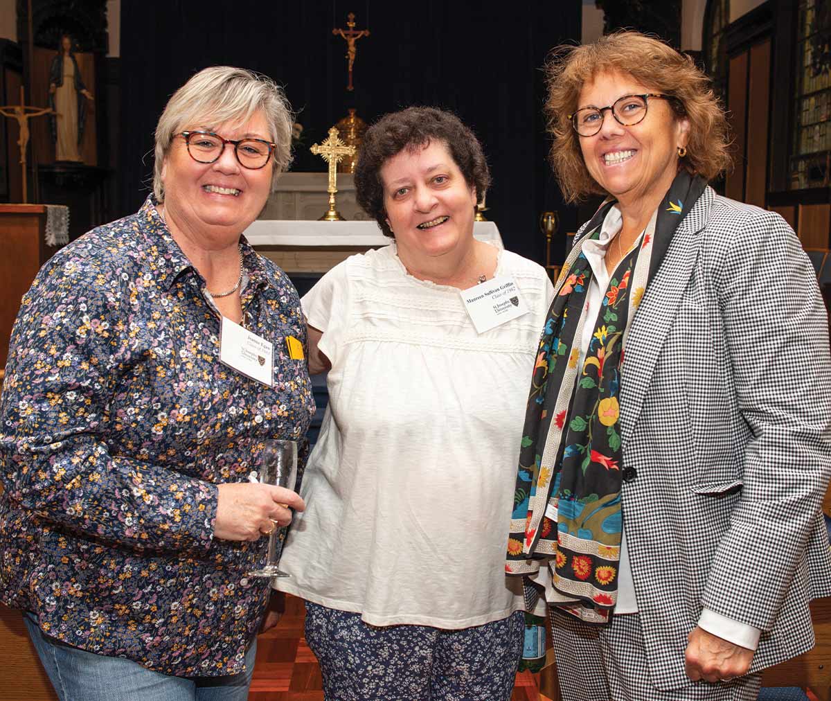 Three women standing together and smiling