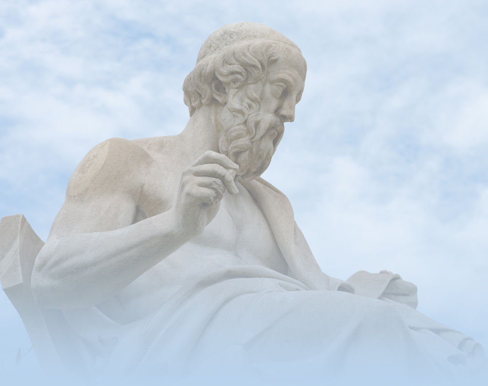 Marble statue of a seated bearded man against a cloudy sky.