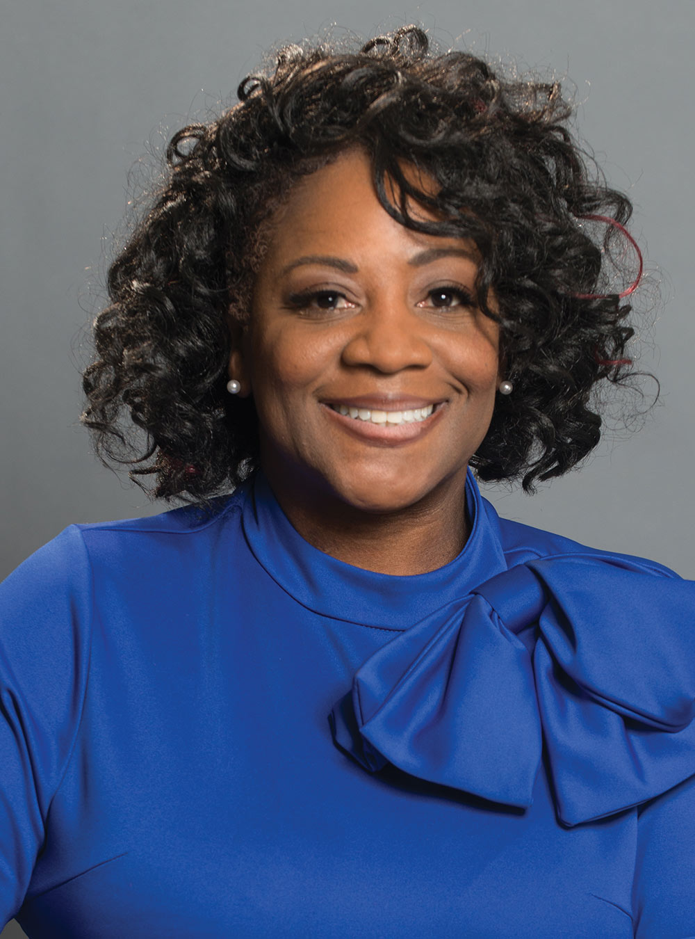 headshot of LaQuetta Solomon wearing a blue blouse with a large bow