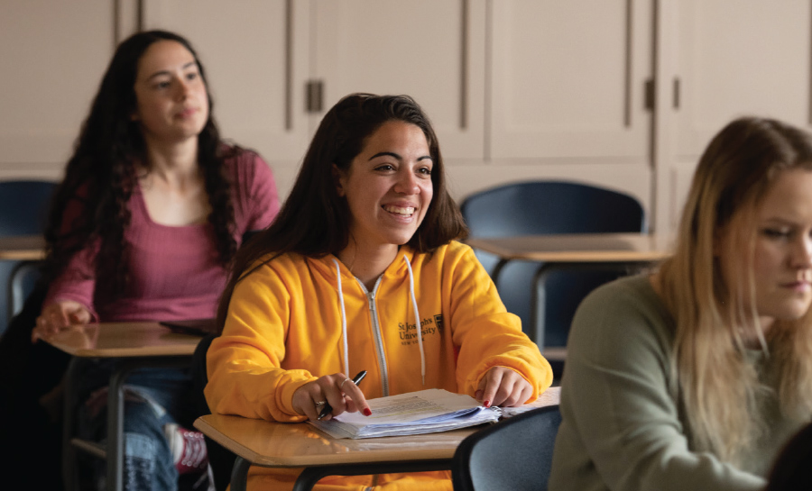 female students sitting in desks in classroom