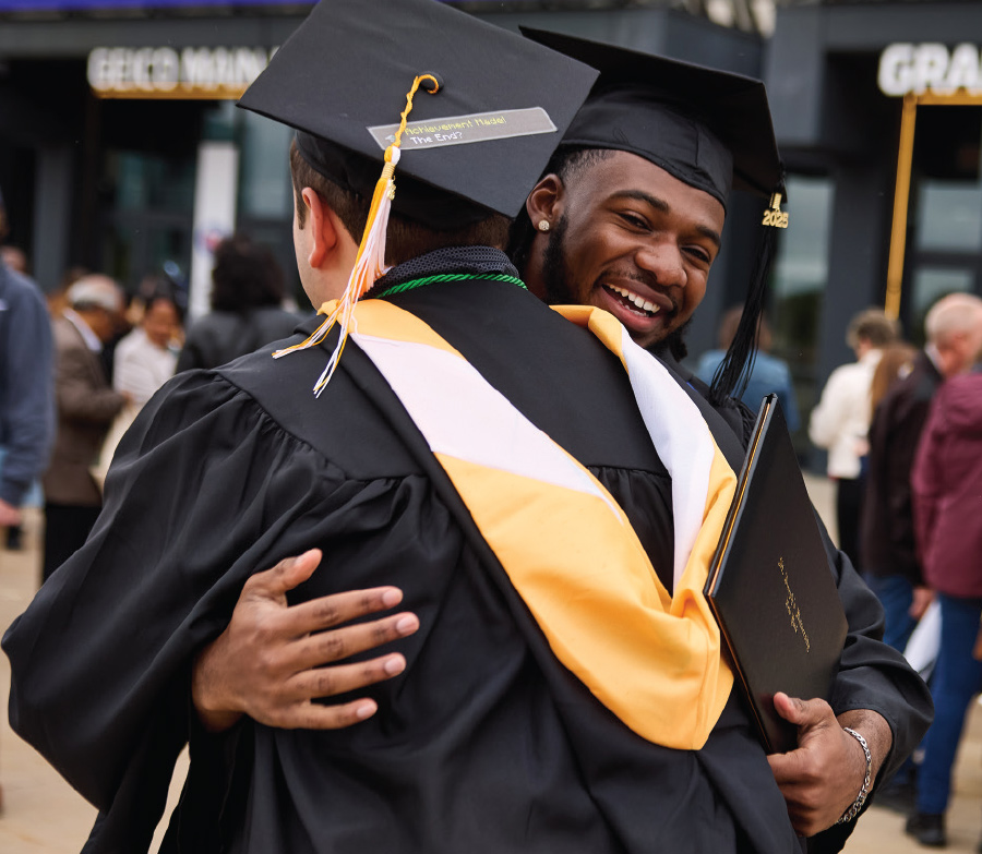 two male students hugging and smiling