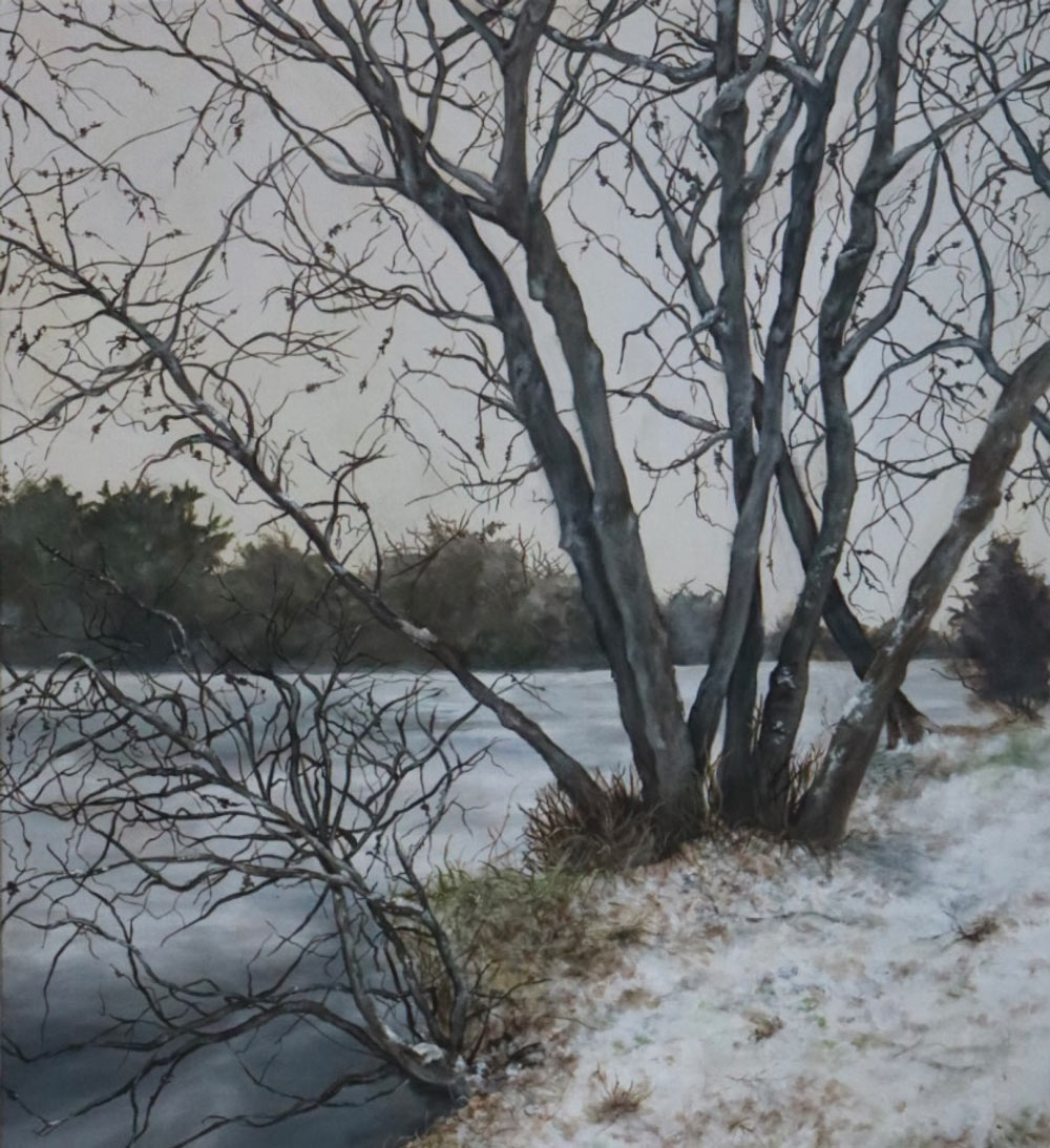 A realistic painting of a winter landscape featuring a cluster of bare, dark-limbed trees on a snowy riverbank. The frozen water is a muted grey under a pale, overcast sky.