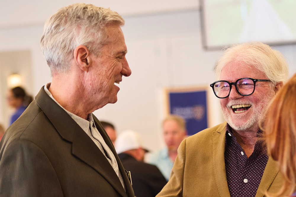John Roth and Donald R. Boomgaarden laughing together at an event.